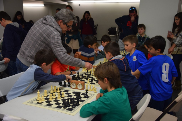 Kinder beim Schachspielen unter Beobachtung von Erwachsenen