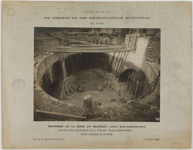 Schwarzes und weißes Foto eines im Bau befindlichen Tunnels mit einem Stempel links und Text unten.