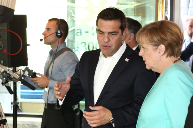 Bundeskanzlerin Angela Merkel und Bundespräsident Joachim Gauck vor einer Glaswand mit Vorhang, in Anzüge gekleidet und in Mikrofone sprechend.