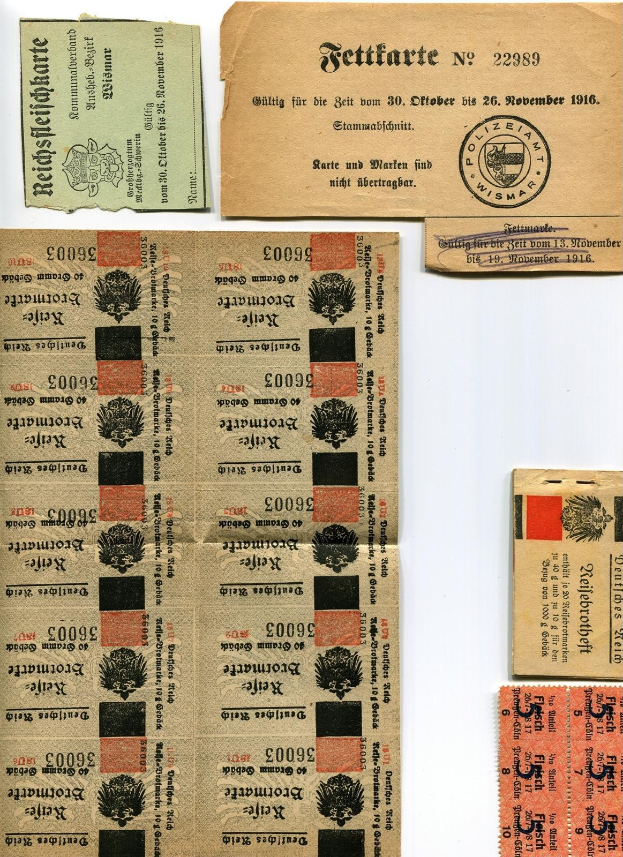 Sammlung alter deutscher Eintrittskarten und Briefmarken auf einem weißen Hintergrund, mit abgenutztem Papier und gedrucktem Text und Zahlen.