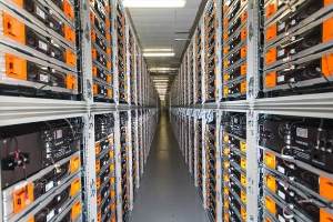 Lange Reihe von Servern in einem Rechenzentrum mit elektronischen Geräten in den Räumen und Anzeigelämpchen oben.