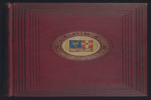 Ein rotes Journal mit glänzendem Finish und goldenem Rand, das ein goldenes Wappen eines Löwen in einem Schild zeigt, umgeben von einem Lorbeerkranz und einem Banner mit der Aufschrift "Fünfzig Jahre Sport", vor einem schwarzen Hintergrund.