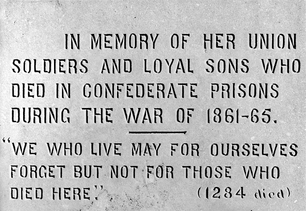 Ein Schwarz-Weiß-Foto einer Steinplatte an einem Gebäude, auf der ein Text eingraviert ist, der Union-Soldaten und treue Söhne ehrt, die während des Kriegs von 1861-65 in konföderierten Gefängnissen starben.