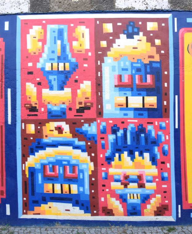 Leuchtendes Wandgemälde an einem Gebäude in Berlin, bestehend aus verschiedenen Farben und abstrakten Formen.