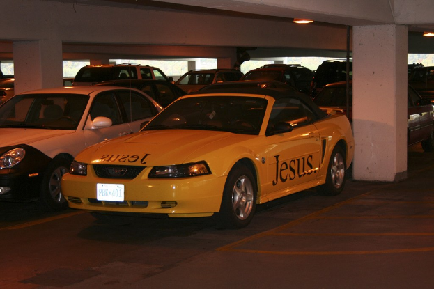 Ein Parkplatz mit zahlreichen Autos vor einem Geb├Ąude.