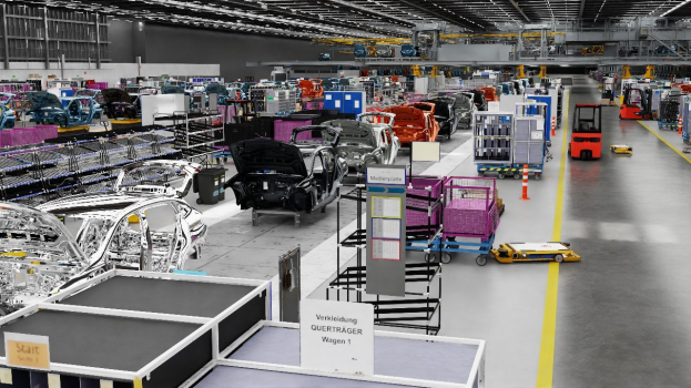 Large factory with multiple cars on an assembly line, metal structures on the sides, a wall in the background, and ceiling lights, with "Volkswagen" text visible.