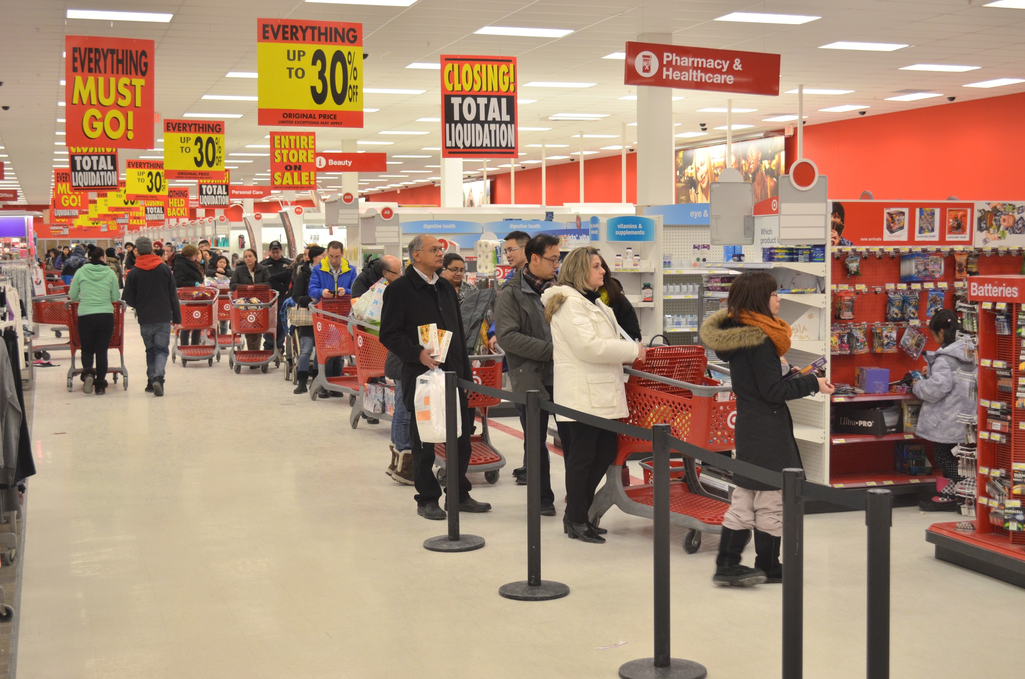 Ein überfüllter Walmart-Laden am Black Friday, mit Einkaufswagen, Taschen und Kunden, die Waren inspizieren.