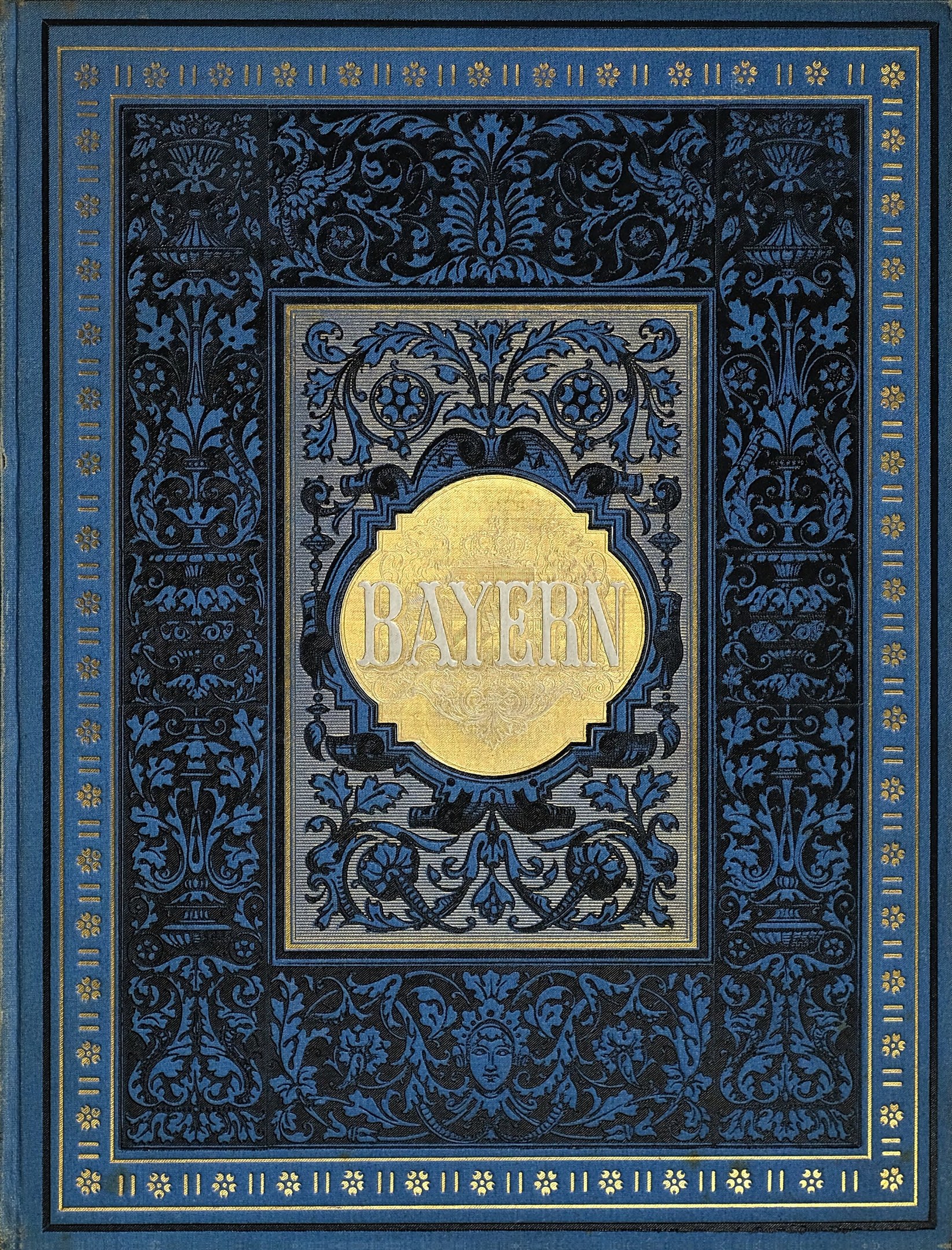 Ein blau-goldenes Buch mit dem Wort "Bayern" auf dem Cover, das mit detailreichen Verzierungen versehen ist.