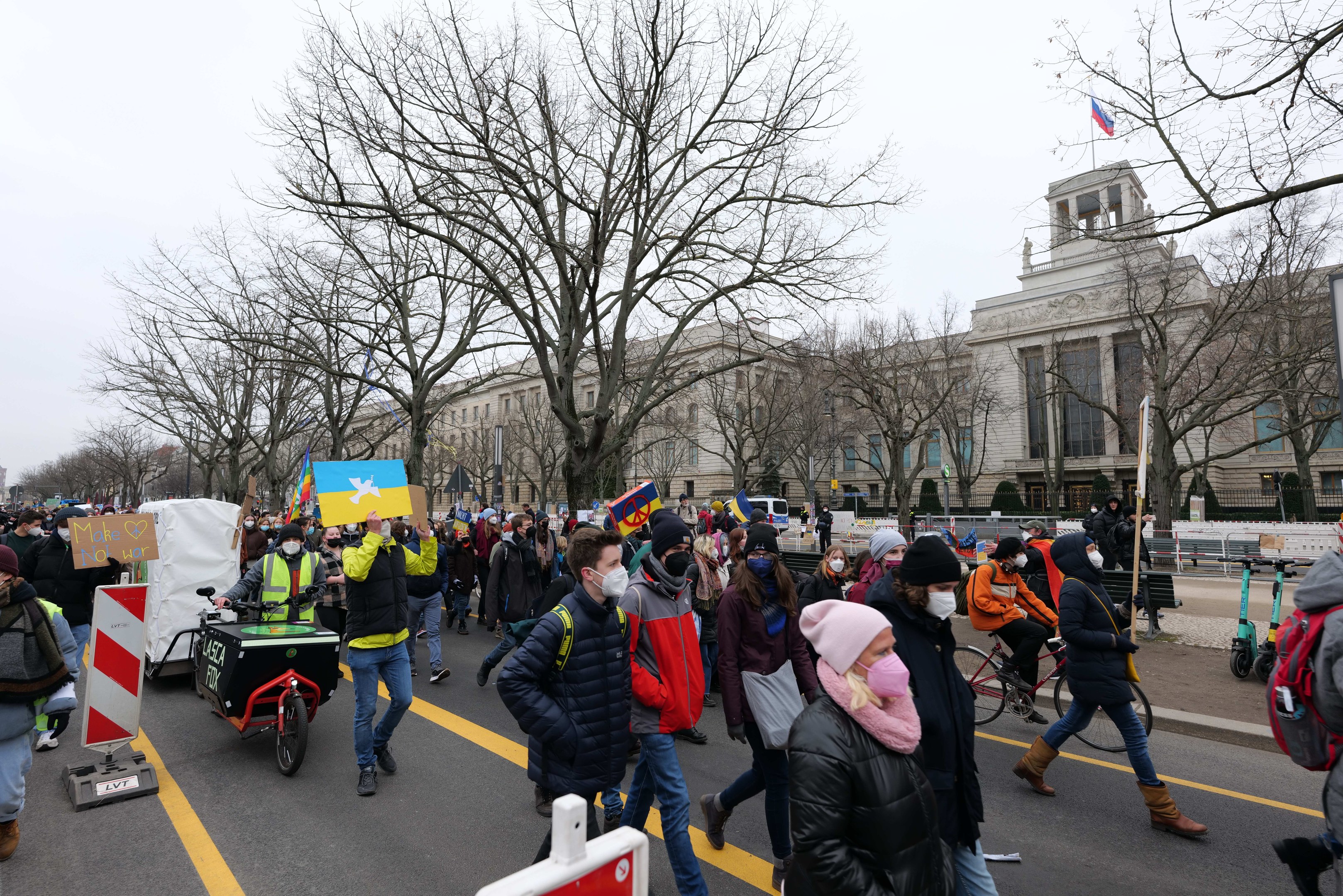 Eine große Gruppe von Menschen bei einer Protestdemo auf einer Stadtstraße, einige halten Schilder und andere fahren Fahrräder, mit Bäumen und einem Gebäude im Hintergrund unter einem klaren blauen Himmel in Washington, D.C. am 21. Januar 2020.