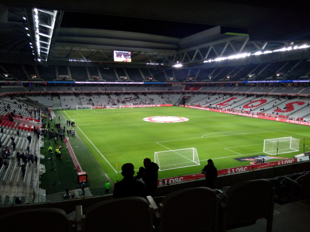 Großes Stadion voller Zuschauer bei einem Fußballspiel im Estadio Santiago Bernabeu, Madrid, Spanien, unter Stadionbeleuchtung mit einem Bildschirm oben.